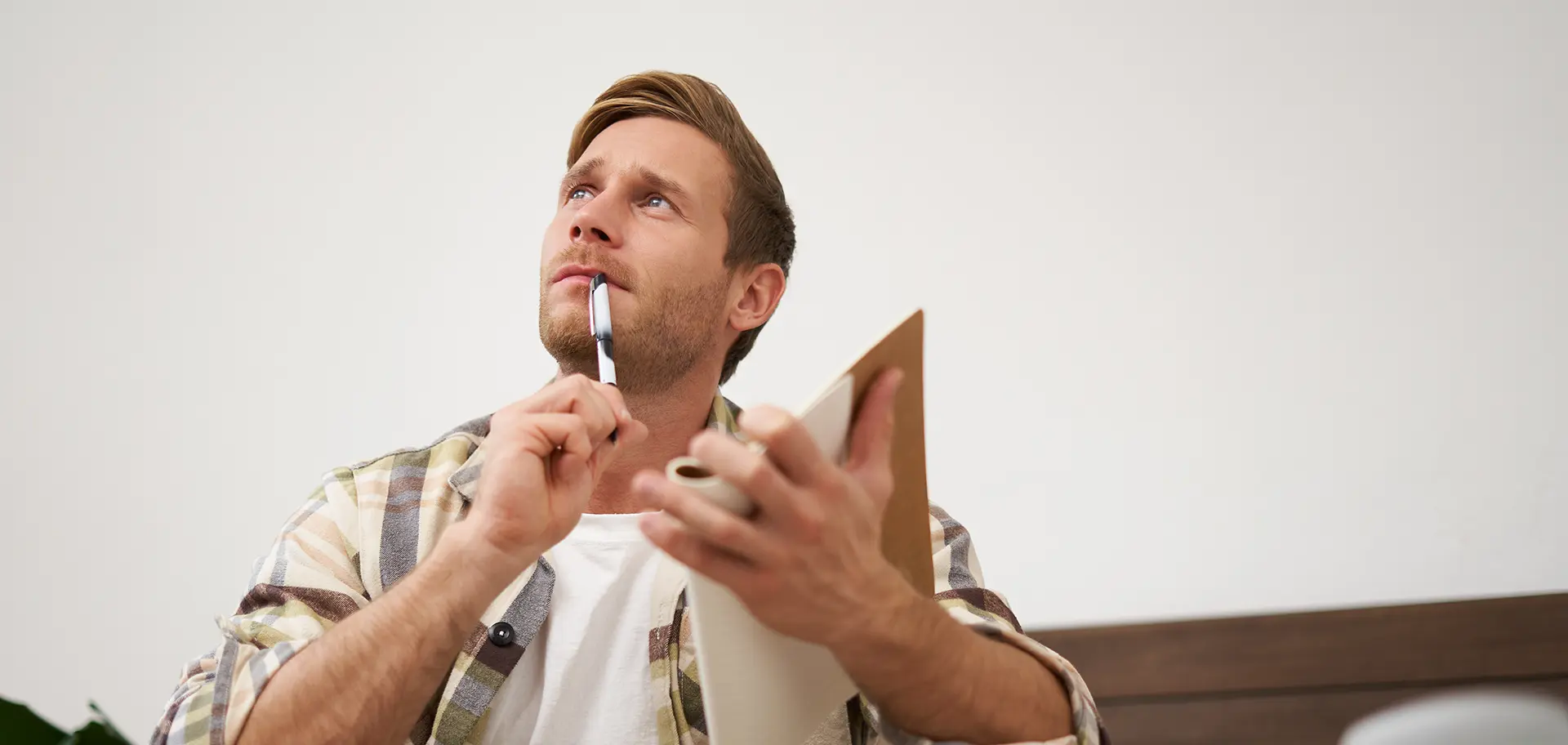Hombre pensativo con libreta en mano analizando opciones de calderas para el hogar
